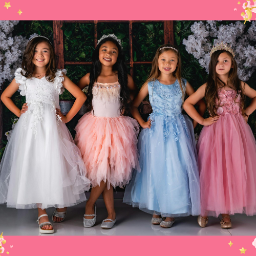 Four young girls dressed in elegant pastel princess gowns with tiaras, posing confidently at a fairy-tale themed princess party, surrounded by floral decorations.